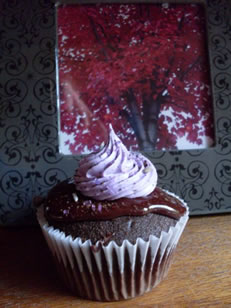 Etched chocolate cupcake with chocolate coat and a poof of cream